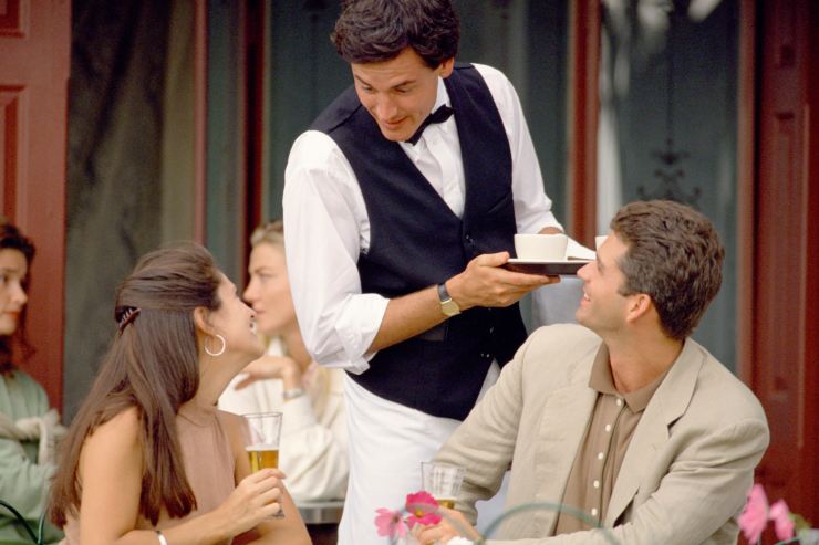 Cameriere che chiacchiera con i clienti