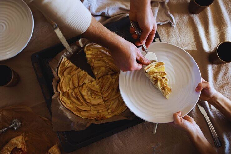 Uomo mette nel piatto fetta di torta alle mele