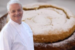 Iginio Massari in primo piano e torta