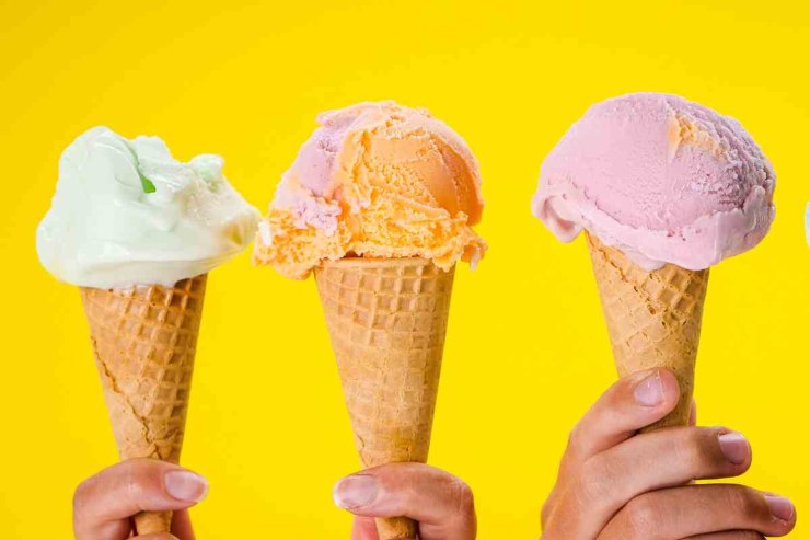 3 coni di gelato con gusto differente su sfondo giallo 
