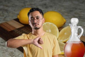 Persona con pollice in giù, aceto e limone