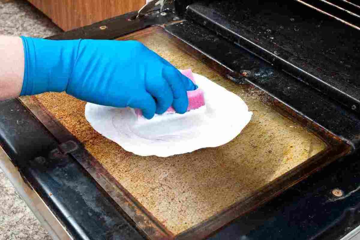 donna che pulisce forno incrostato