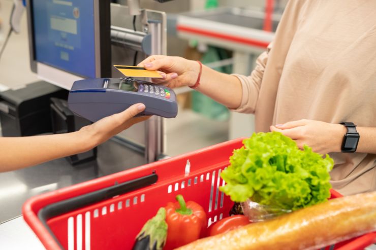 Cliente che paga la spesa con il pos alla commessa del supermercato