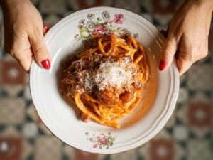 Signora tiene un piatto di pasta al ragù