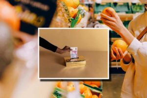 Una donna che compra frutta al supermercato e, in evidenza, un mano che infila 500 euro in una scatola