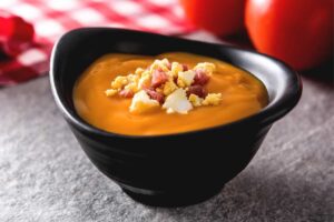 scodella nera con zuppa arancione e crostini