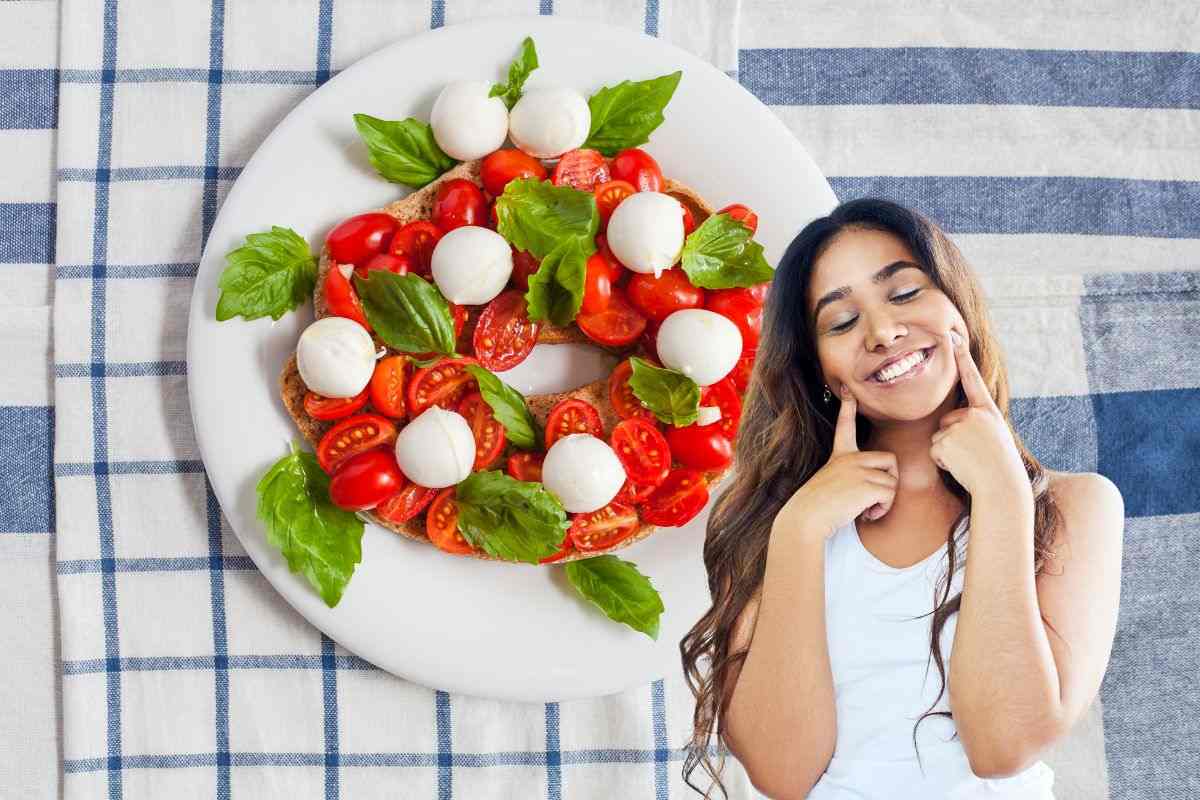 piatto con fresella, pomodorini e mozzarella e donna che simula il gesto buono