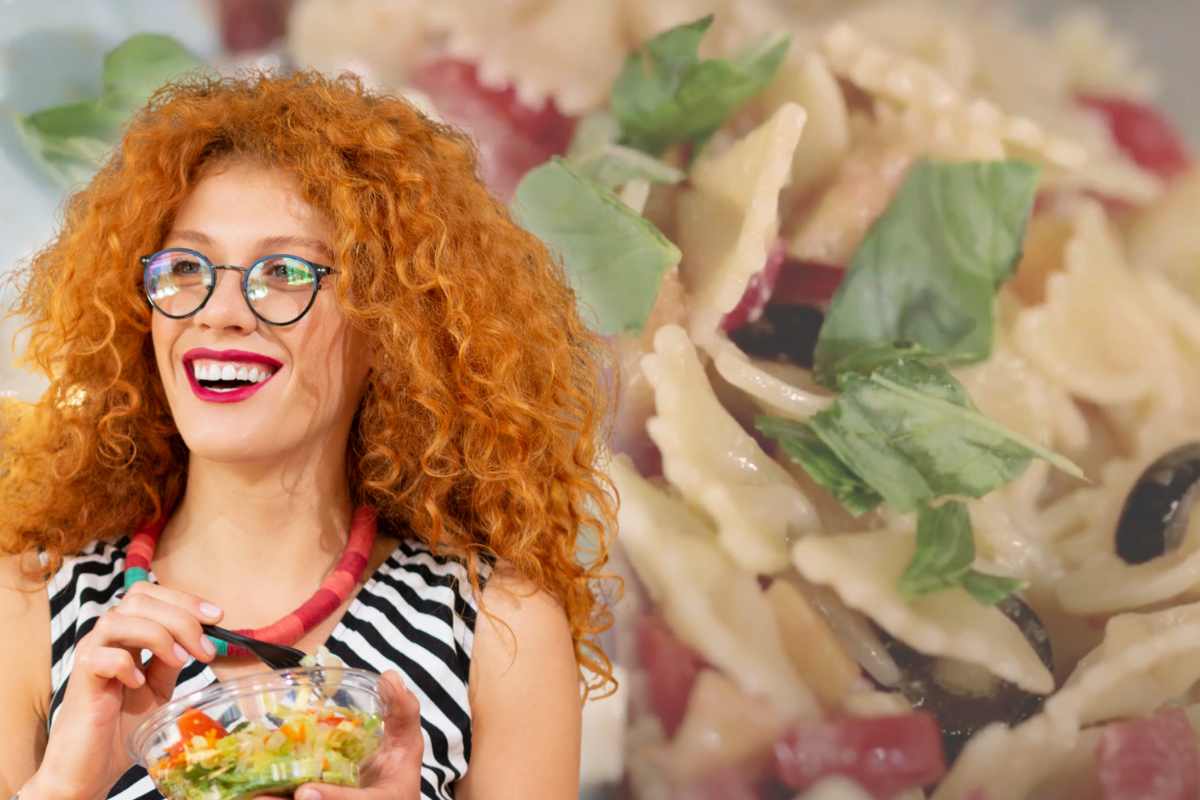 donna che mangia e insalata di pasta come sfondo