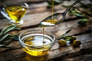 Ciotola con olio d'oliva, cucchiaio, olive