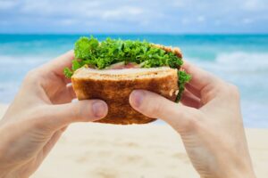 mani con panino in spiaggia