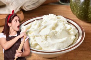 Donna con grembiule e mattarello indica crema