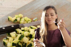 zucchine tagliate e donna che mangia