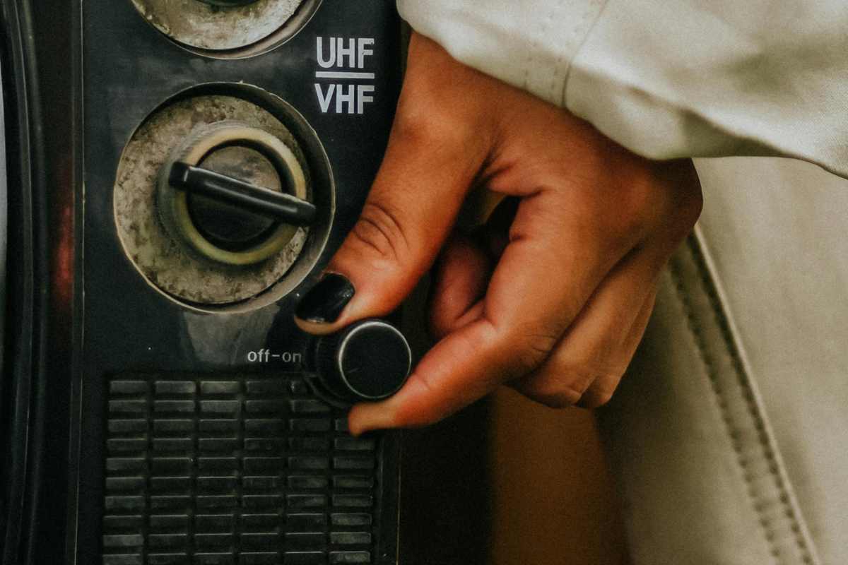 Una mano che spegne una vecchia televisione