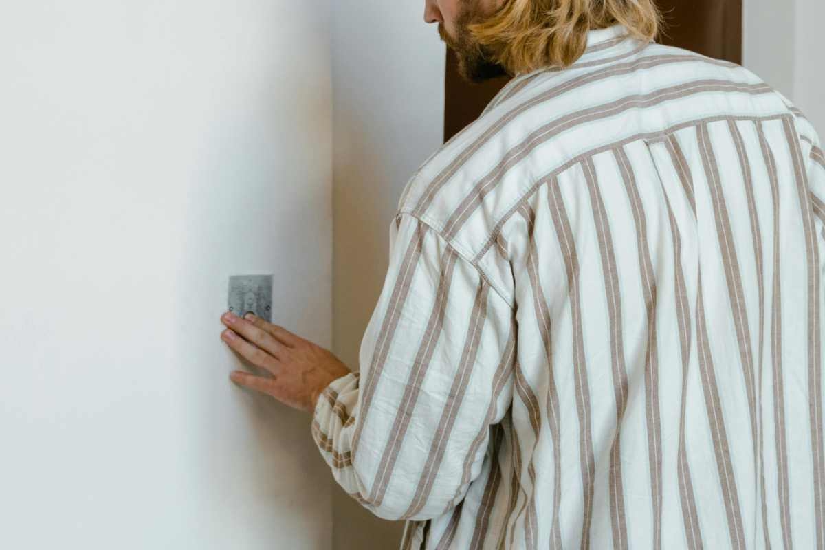 Un ragazzo con una camicia a righe che spegne un interruttore
